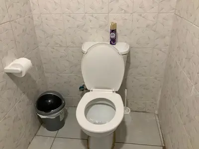 a small bathroom with a toilet with a can of soda at GTI Guest House in Pretoria