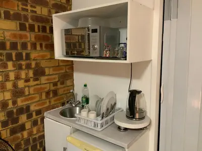 a kitchen with a sink and a microwave at GTI Guest House in Pretoria