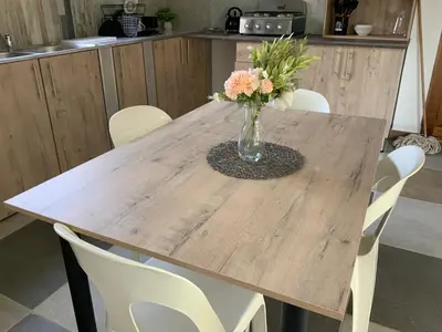 a wooden table with a vase of flowers on it at GTI Guest House in Pretoria