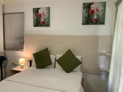 a bedroom with a bed with green and white pillows at GTI Guest House in Pretoria