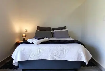 a bedroom with a large bed with two pillows at Pretorius Park in Hartbeespoort