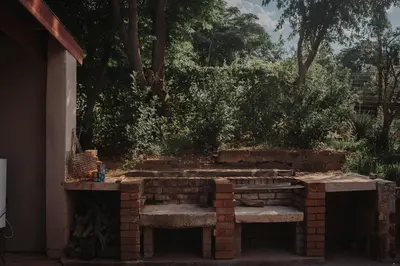 a brick retaining wall with a bench in a yard at Pretorius Park in Hartbeespoort