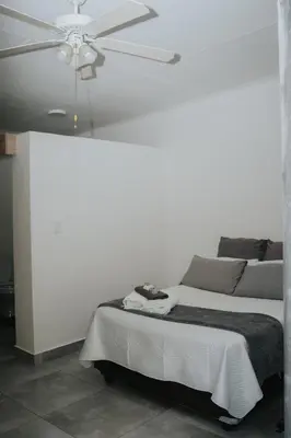 a bedroom with a bed with a ceiling fan at Pretorius Park in Hartbeespoort