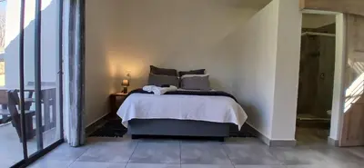a bedroom with a bed in a white room at Pretorius Park in Hartbeespoort