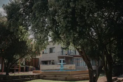 a building with a fountain in front of a building at Pretorius Park in Hartbeespoort