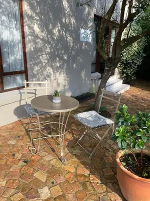 a table and two chairs on a brick patio at Olive Branch Cottage off grid in Benoni