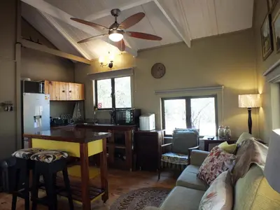 a kitchen and living room with a ceiling fan at Pheasant's Crest in Marloth Park