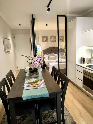 a dining room table with a kitchen and a bedroom at Ellipse Waterfall Luxury Sapphire in Midrand