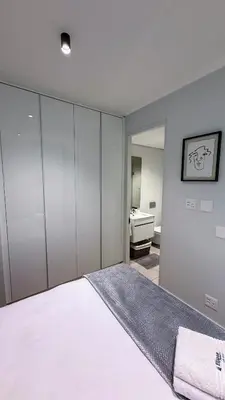 a bedroom with a white bed and a mirror at Ellipse Waterfall Luxury Sapphire in Midrand