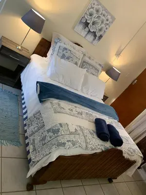 a bedroom with a bed with a newspaper at Cottage 32 in Groblersdal
