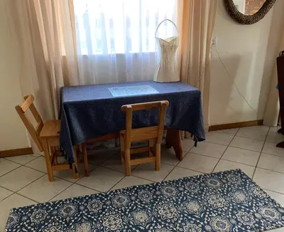 a blue table with two chairs and a dress on it at Cottage 32 in Groblersdal
