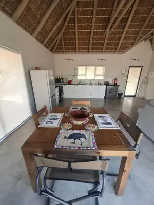 a table and chairs in a room with a kitchen at Amukela Kaya in Hoedspruit