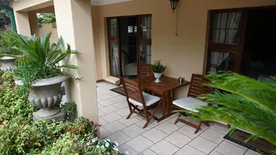 a patio with a table and chairs and plants at LUXURY ROOM @ 4 STAR GUEST HOUSE in Middelburg