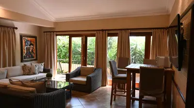 a living room with a couch and a table and chairs at LUXURY EN-SUITE ROOM WITH LOUNGE @ 4 STAR GUEST HOUSE in Middelburg