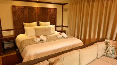 a hotel room with a bed and a couch at LUXURY EN-SUITE ROOM WITH LOUNGE @ 4 STAR GUEST HOUSE in Middelburg