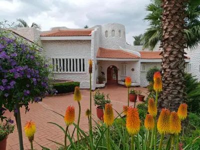 a house with flowers in front of it at Villa Sardinia Guest House in Midrand