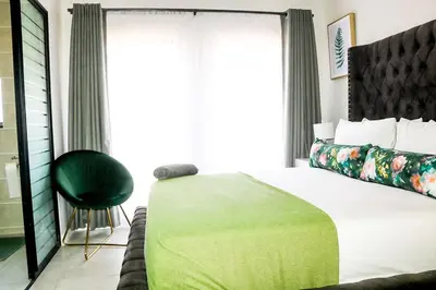 a bedroom with a bed with a green blanket on it at Twelve Eighty at The Blyde Crystal Lagoon in Pretoria