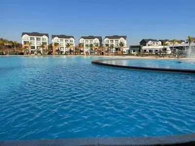 a large swimming pool with houses in the background at RnR Crystal Lagoon in Pretoria