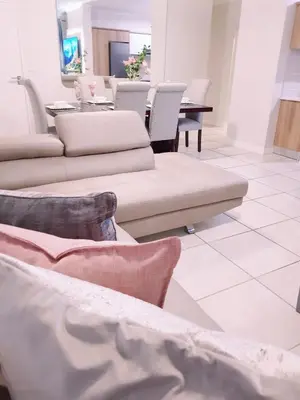 a living room with couches and a table with chairs at RnR Crystal Lagoon in Pretoria