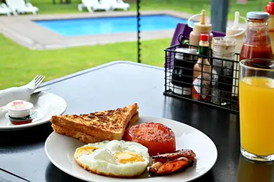 a plate of eggs and toast and a glass of orange juice at SleepOver Orpen Gate in Acornhoek