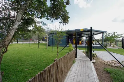 a bus stop in a park with a fence at SleepOver Orpen Gate in Acornhoek