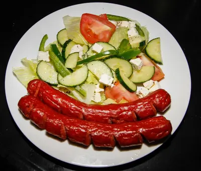 a plate of food with two hot dogs and vegetables at SleepOver Beitbridge in Musina