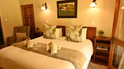 a bedroom with a bed with two stuffed animals on it at LUXURY EN-SUITE KING ROOM @ 4 STAR GUEST HOUSE in Middelburg
