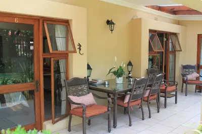 a dining room with a table and chairs at LUXURY EN-SUITE KING ROOM @ 4 STAR GUEST HOUSE in Middelburg