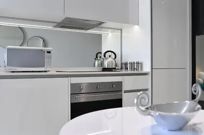 a white kitchen with a sink and a microwave at Ellipse Waterfall Executive Apartments in Midrand