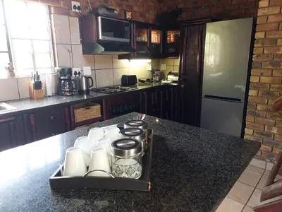 a kitchen with a counter top with a tray with cups at Khumbula iAfrica 2 in Marloth Park