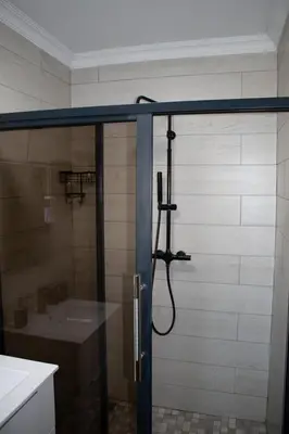 a shower in a bathroom with a sink at Locust Retreat Immaculate 2bedroom cottage in Marloth Park