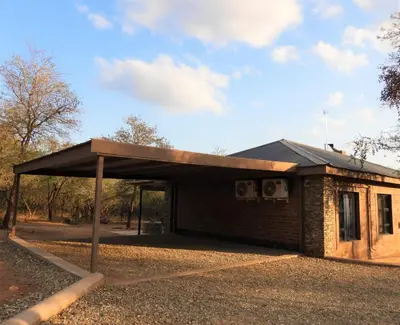 a building with a roof on the side of it at Locust Retreat Immaculate 2bedroom cottage in Marloth Park