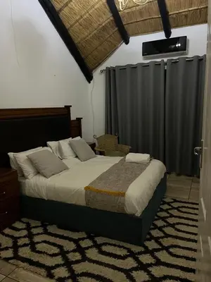 a bedroom with a large bed with a curtain at Goldpot Faerie Glen near Sun Bet Arena in Pretoria