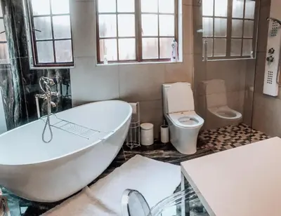 a bathroom with a tub and a toilet at Goldpot Faerie Glen near Sun Bet Arena in Pretoria