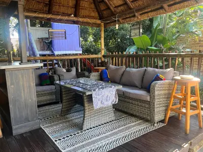 a patio with a couch and a table on a deck at Goldpot Faerie Glen near Sun Bet Arena in Pretoria