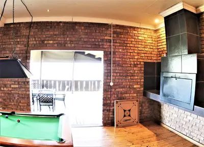 a kitchen with a pool table and a brick wall at Waterval Self-Catering Holiday Home in Sabie