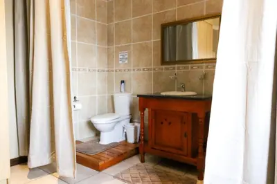 a bathroom with a toilet and a sink and a mirror at Waterval Self-Catering Holiday Home in Sabie