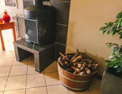 a wood stove in a room with a bucket of mushrooms at Waterval Self-Catering Holiday Home in Sabie