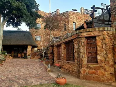 a large stone building with a brick walkway in front of it at Bronberg Bastion in Tierpoort