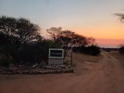 a sign sitting on the side of a dirt road at Isilwane Bush Camp in Pretoria