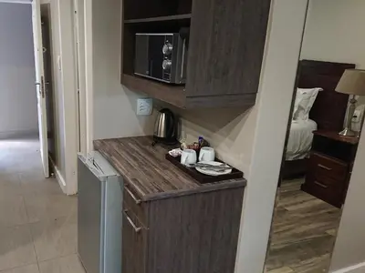 a small kitchen with a counter and a microwave at Unitas Guesthouse in Centurion