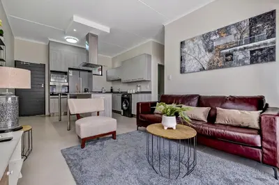 a living room with a couch and a table at Smart Apartment in Midrand