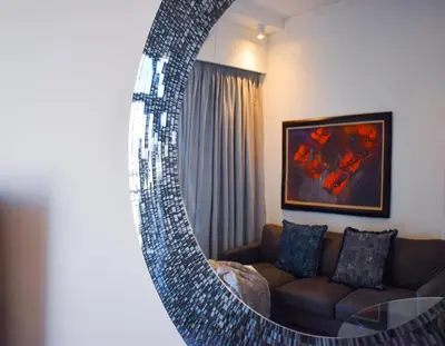 a living room with a couch and a mirror at Menlyn Apartment - Red Velvet in Pretoria