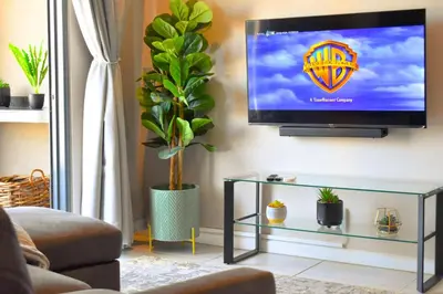 a living room with a flat screen tv on a wall at Menlyn Apartment - Red Velvet in Pretoria