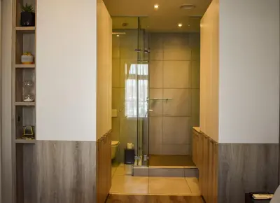 a bathroom with a shower with a glass door at Menlyn Apartment - Red Velvet in Pretoria