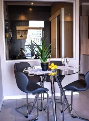 a dining room table with chairs and a plant on it at Menlyn Apartment - Red Velvet in Pretoria