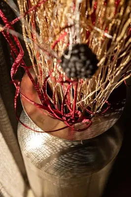 a glass vase filled with red and gold decorations at Kruger River Lodge in Hoedspruit