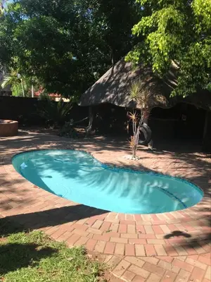 a small blue swimming pool on a brick yard at Danamara Garden Studios in Phalaborwa