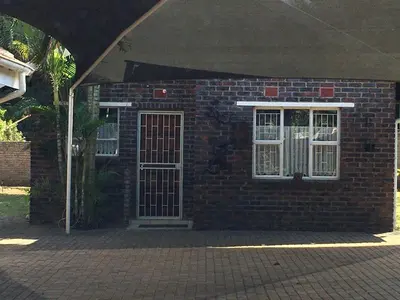a brick house with a door and two windows at Danamara Garden Studios in Phalaborwa