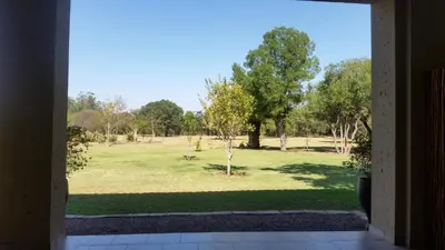 an open door with a view of a park at Summerset Place Country House in Bela-Bela